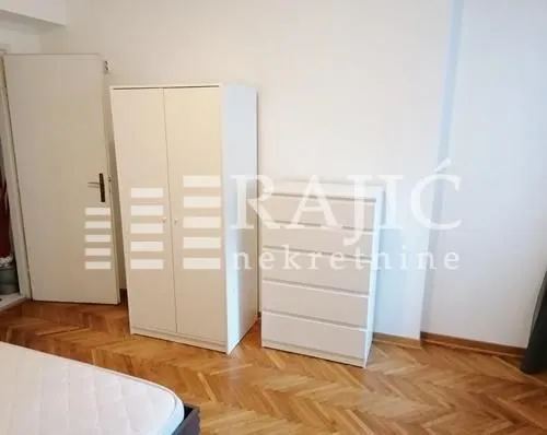 Furnished bedroom with a wardrobe and chest of drawers.
