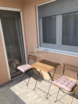 Small balcony with a wooden table and two chairs. - image 13