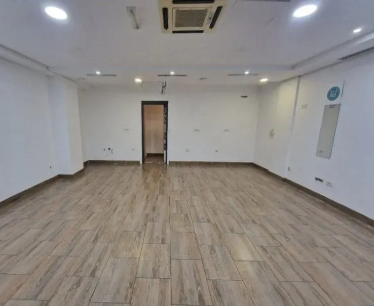 An empty, spacious room with light floor tiles.