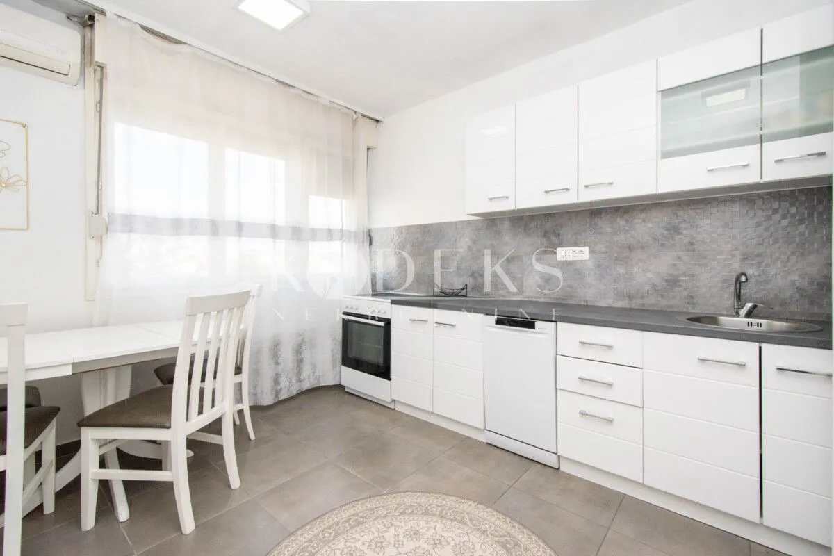 White kitchen with a dining table and a window.