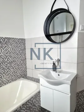 Bathroom with a vanity, cabinet, mirror, and bathtub. - image 10