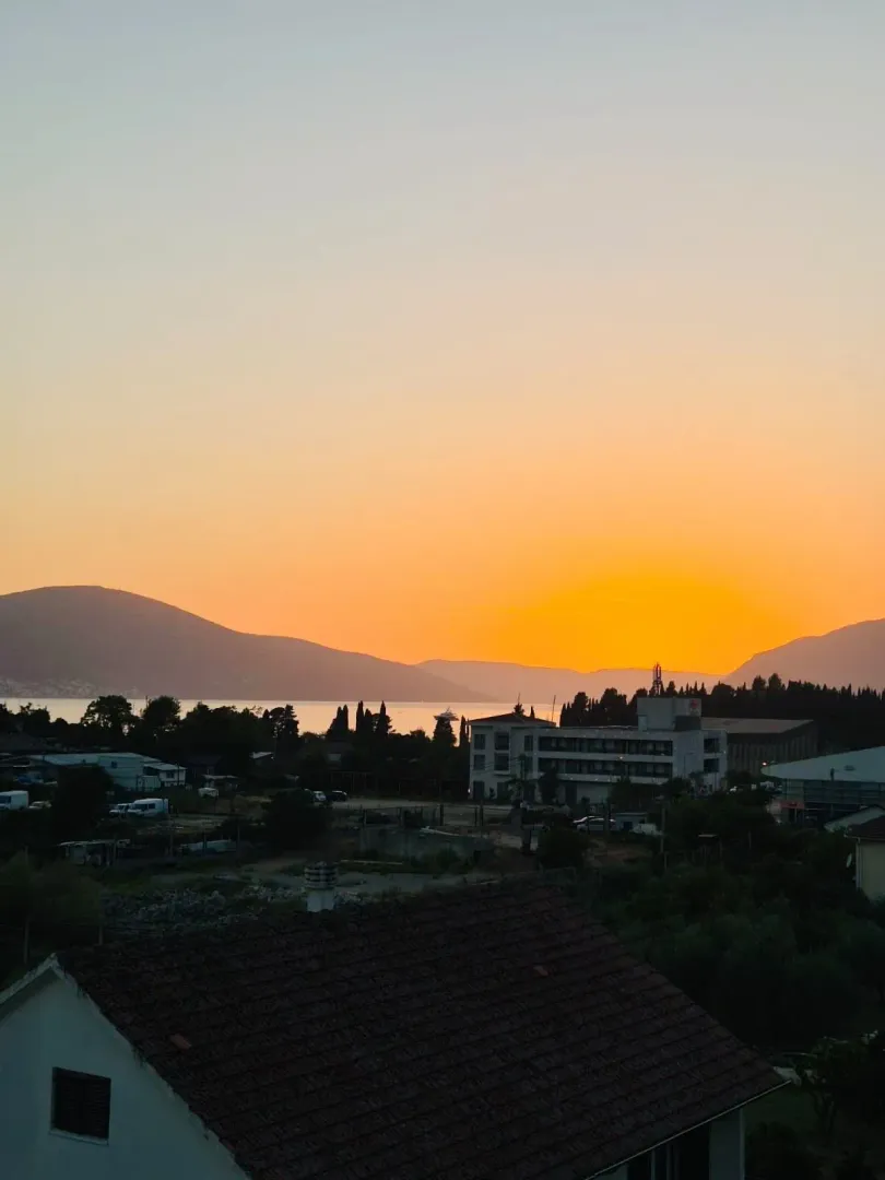 View of the sunset, sea and surrounding buildings from the terrace.
