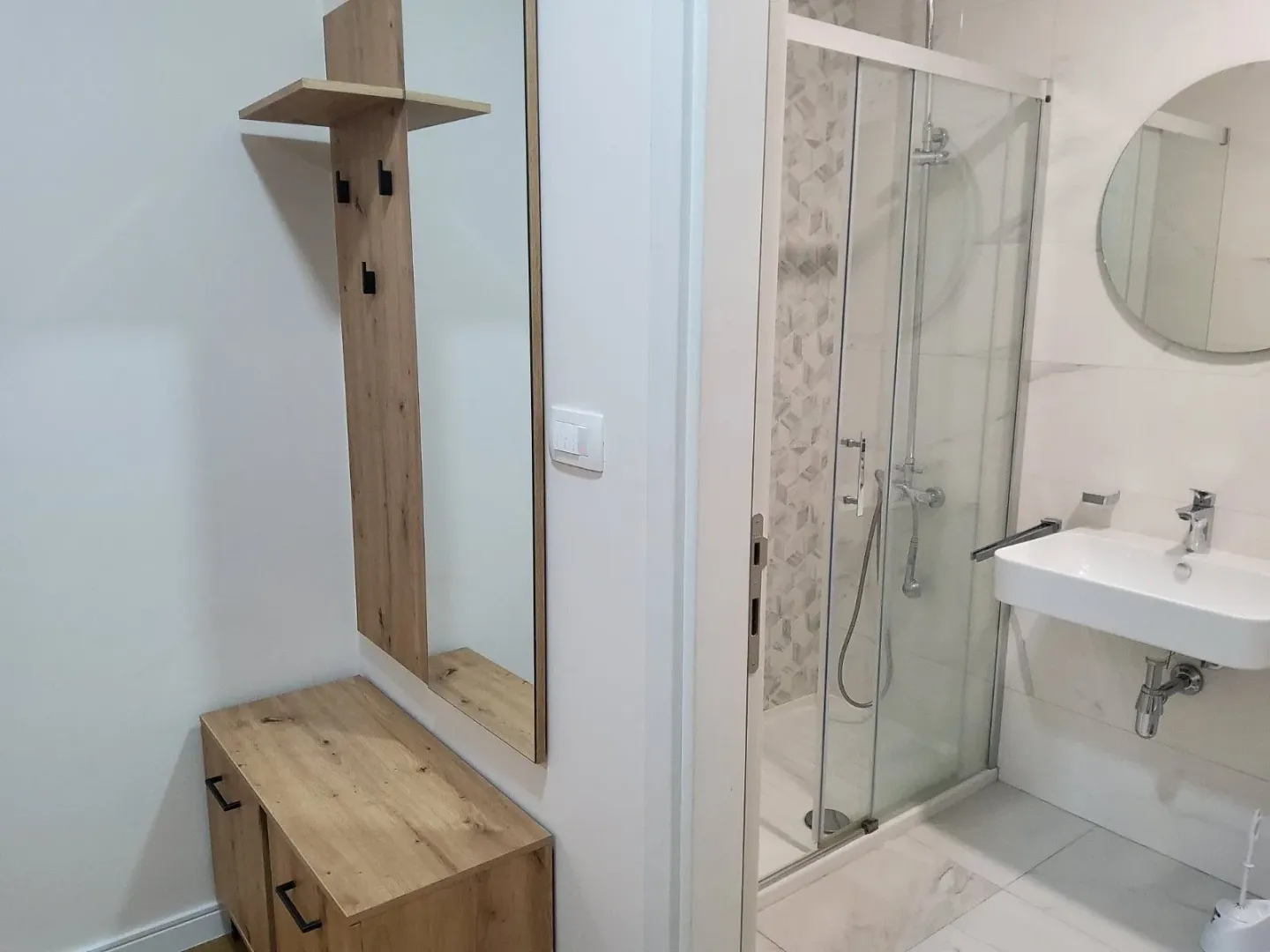 Modernly equipped bathroom with a shower cabin and a washbasin.