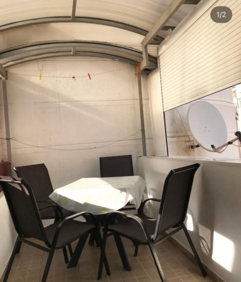 Covered terrace with a table and chairs.