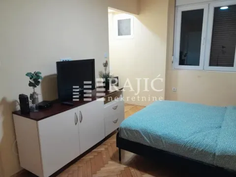Furnished bedroom with a double bed and a TV unit. - image 5