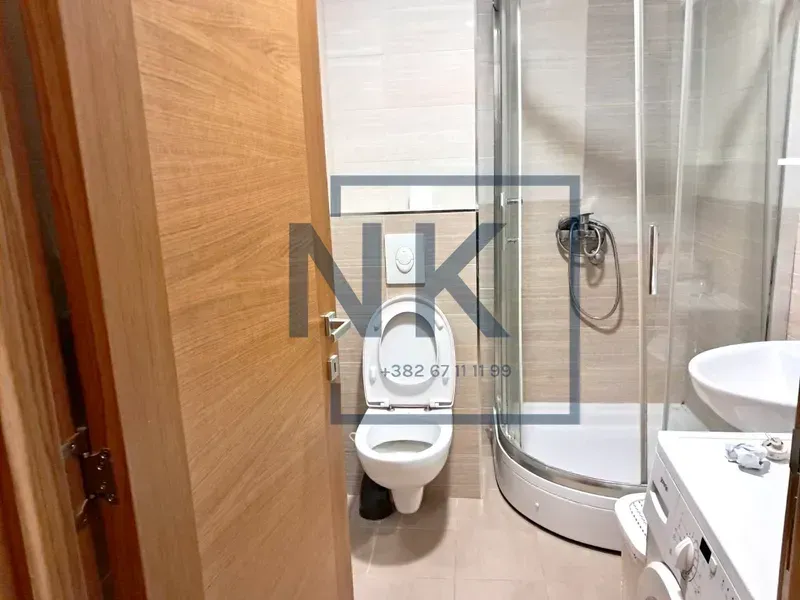 Kupatilo opremljeno tuš kabinom, WC šoljom, umivaonikom i veš mašinom.