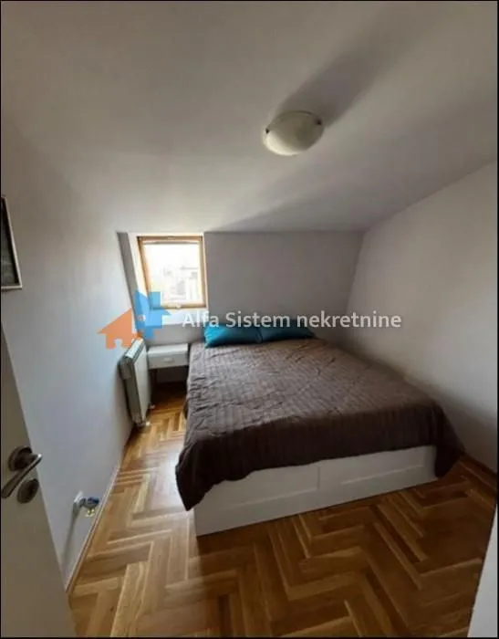 Bedroom with a double bed and a roof window.