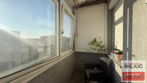 Zastakljeni balkon sa stolicom i saksijama sa biljkama. - image 6