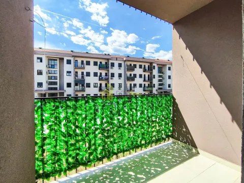 View from the balcony overlooking surrounding buildings and the blue sky. - image 7