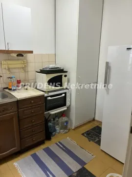 Manja kuhinja sa drvenim elementima, šporetom i frižiderom. - image 7