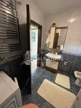 Bathroom equipped with ceramic tiles, vanity sink with cabinet, mirror and toilet. - image 11