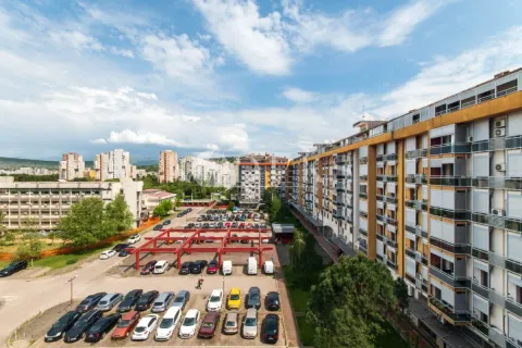 View from the terrace overlooking surrounding residential buildings and a parking lot. - image 8
