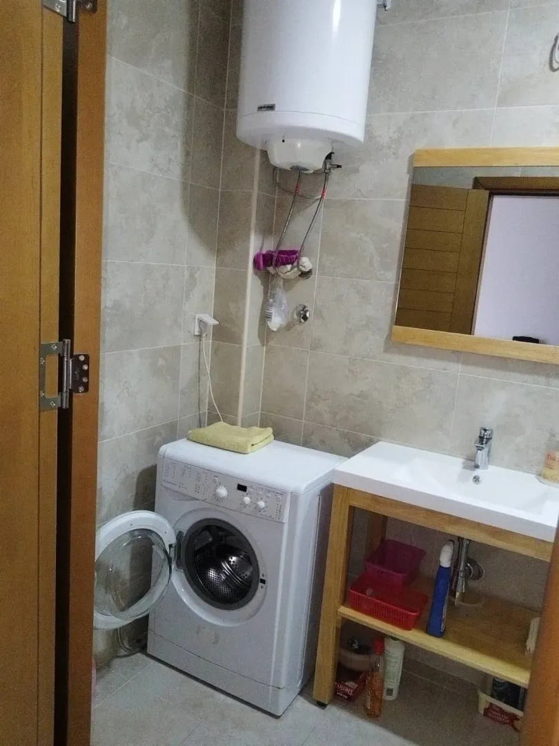 Manje kupatilo sa umivaonikom, veš mašinom i bojlerom.