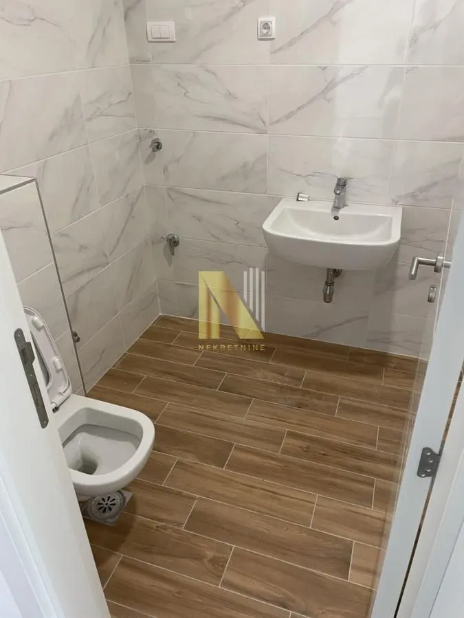 Manje kupatilo sa belim pločicama i sanitarijama.