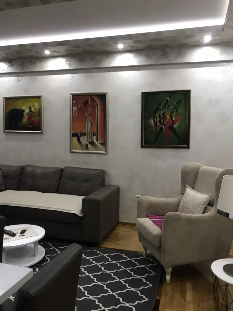 Living room with comfortable seating, artwork on the wall, and decorative lighting.