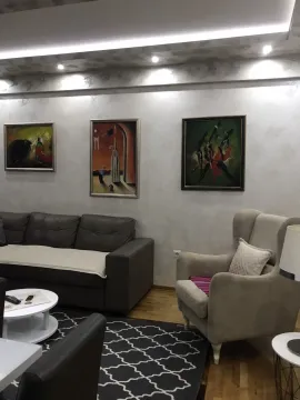 Living room with comfortable seating, artwork on the wall, and decorative lighting. - image 13