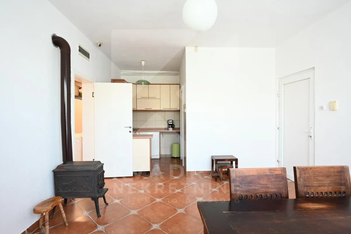 Smaller kitchen with a dining table and a wood-burning stove.