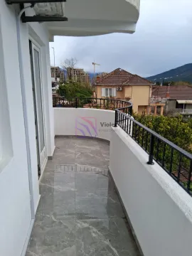 Prostrana popločana terasa sa pogledom na okolne zgrade i brda. - image 6