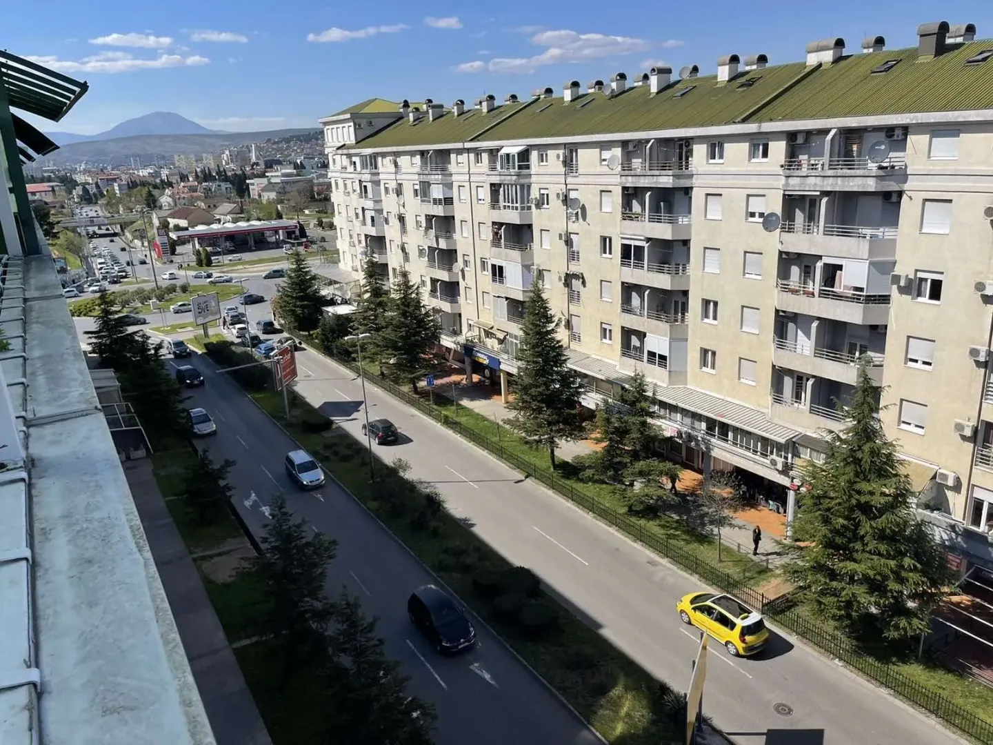 Pogled sa balkona na ulicu i okolne stambene zgrade.