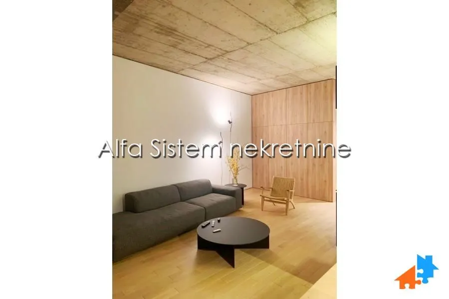 Living room with a sofa, coffee table and wooden wall panels.