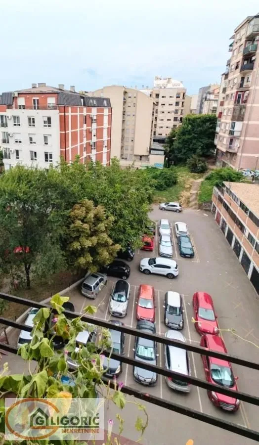 Pogled sa terase na parking i okolne zgrade.