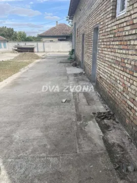Betonsko dvorište pored kuće sa fasadom od cigle. - image 7