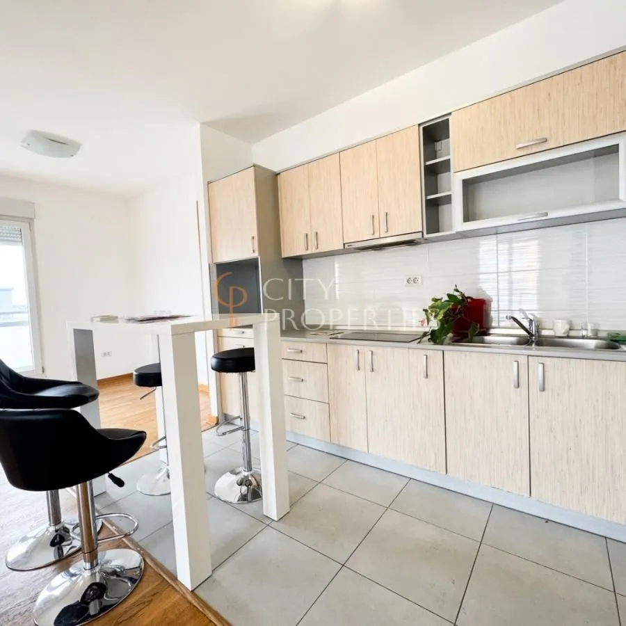Kitchen with wooden cabinetry and a breakfast bar with bar stools.