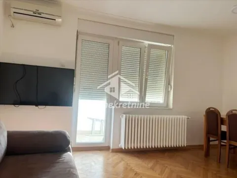 Living room with a sofa, TV, and dining table. - image 3