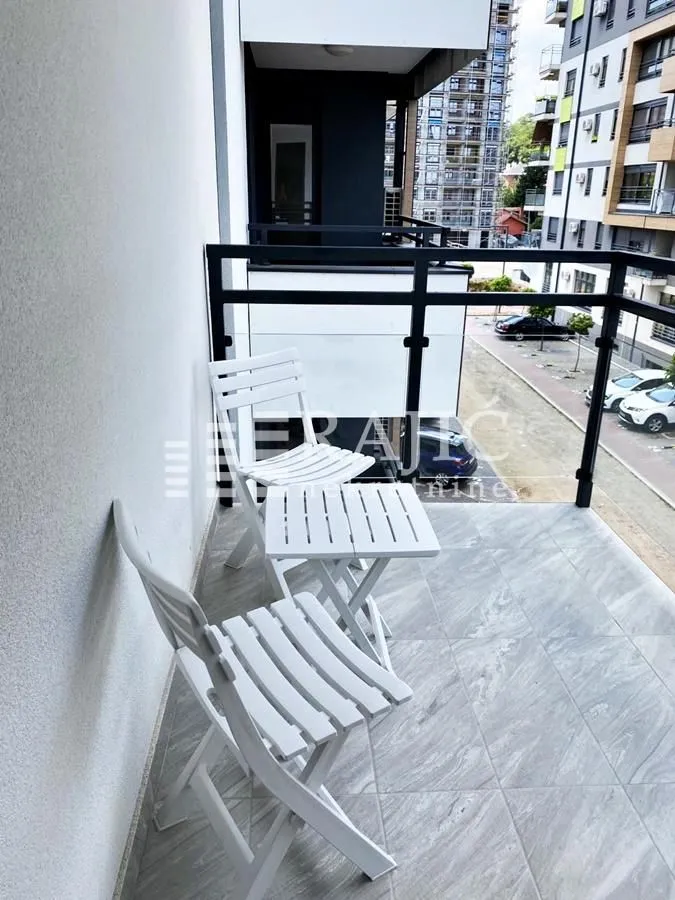 Furnished terrace with seating set and view of surrounding buildings.