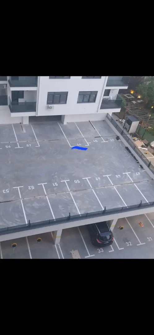 Elevated view of the parking area and the residential building facade.