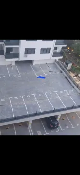 Elevated view of the parking area and the residential building facade. - image 2