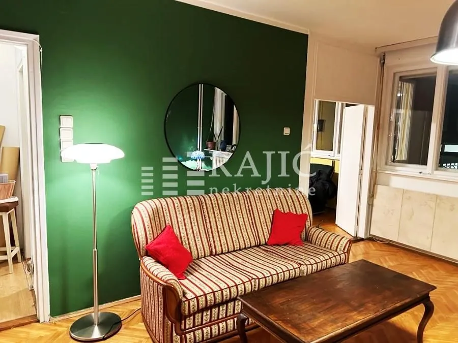 Living room with a sofa, coffee table, and green accent wall.
