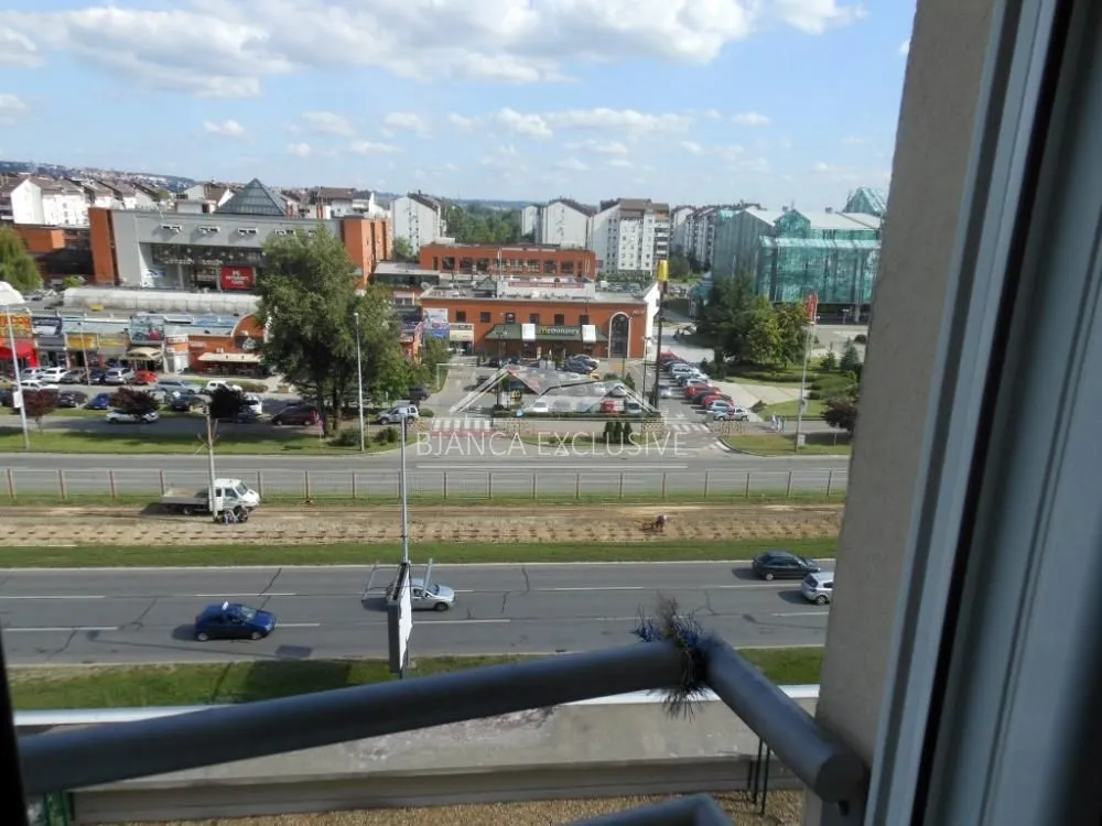 Pogled sa prozora na okolne zgrade i ulicu.