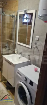 Moderno opremljeno kupatilo sa tuš kabinom i veš mašinom. - image 7