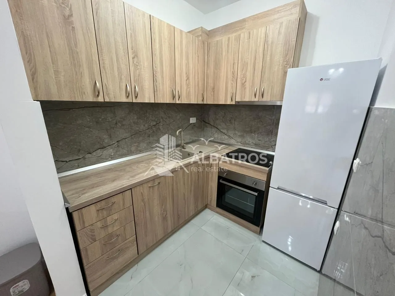 Kitchen with wooden cabinetry and a white refrigerator.