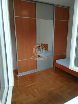 Spavaća soba sa velikim ugradnim garderoberom sa ogledalom i krevetom. - image 4