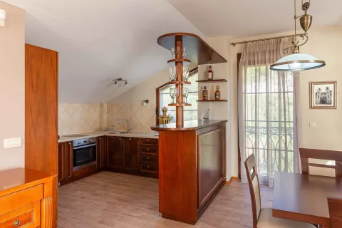 Kuhinja sa drvenim elementima, šankom i trpezarijskim stolom. - image 12