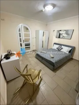 Furnished bedroom with a double bed, wardrobe, and a rocking chair. - image 13