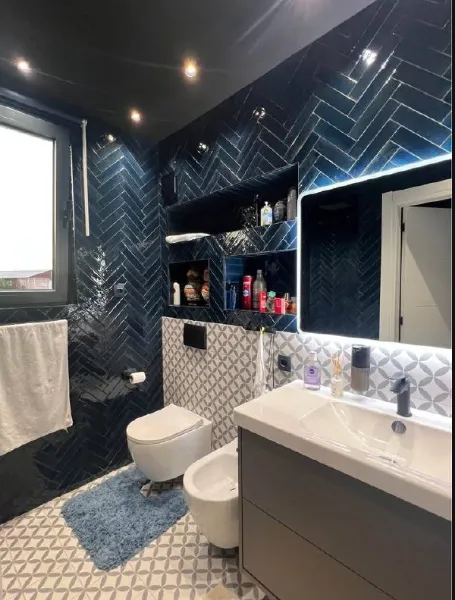 Moderne kupatilo sa plavim pločicama i ugradnim sanitarijama.