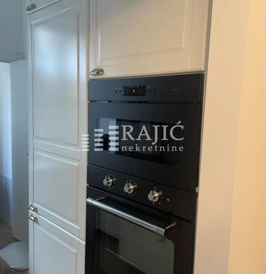 View of the built-in oven and kitchen cabinets.