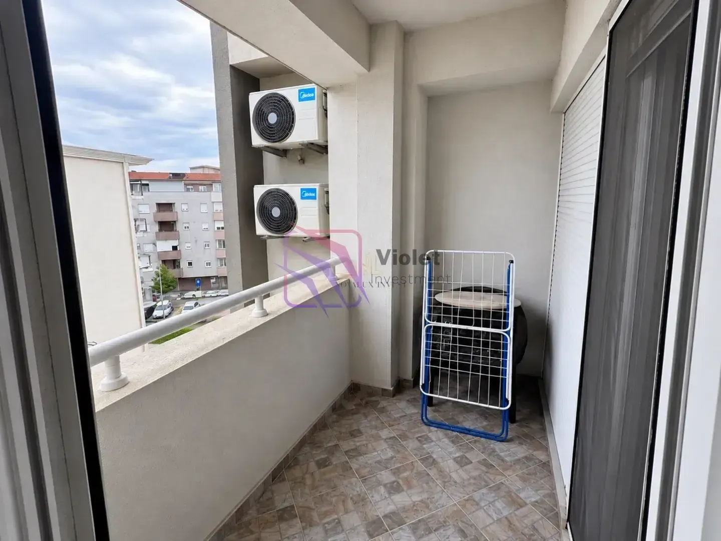 Natkriveni balkon sa klima uređajima i sušačem za veš.