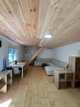 Dnevna soba sa garniturom, trpezarijskim stolom i drvenim plafonom. - image 3