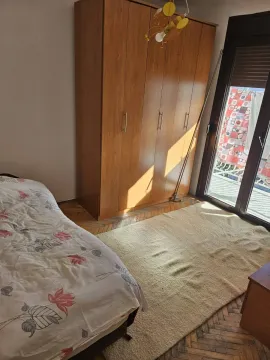 Svijetla spavaća soba sa drvenim ormarom i izlazom na balkon. - image 6