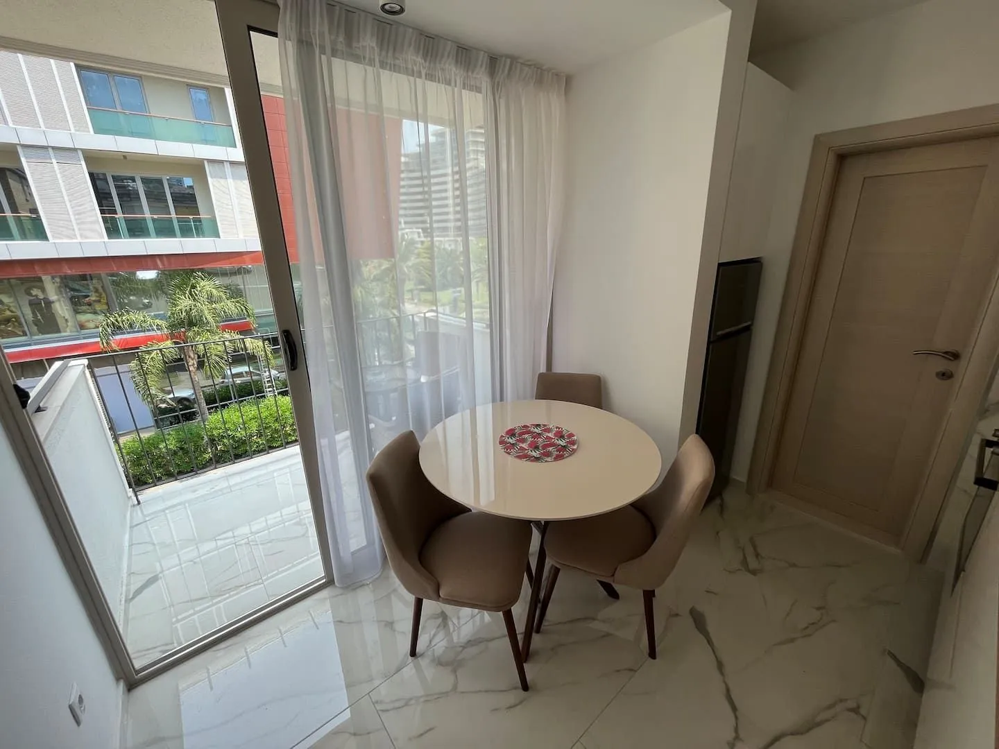 Dining area with a table and chairs next to the balcony doors.