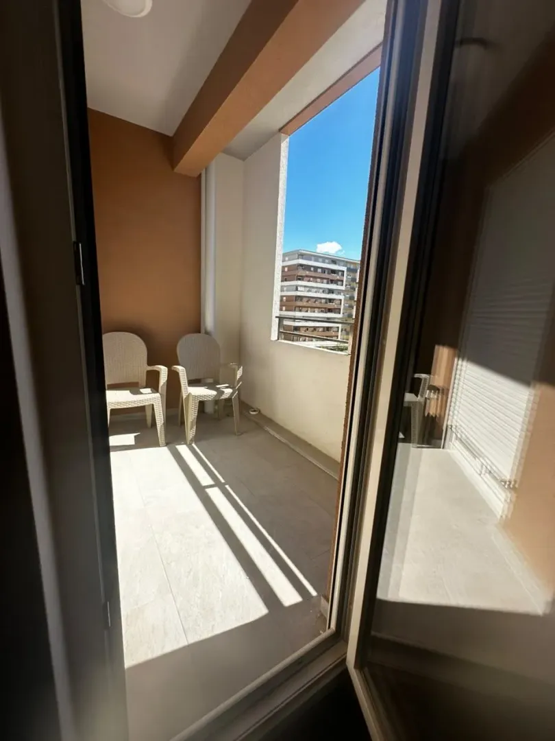 View of the covered balcony with chairs through the open balcony door.