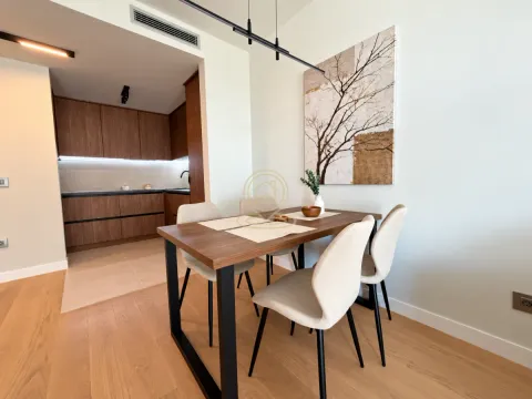 Dining area with a wooden table and chairs, overlooking the kitchen. - image 8