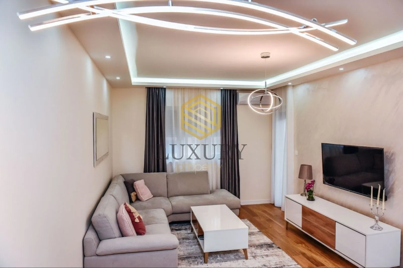 Modern and bright living room with a sectional sofa and a TV.