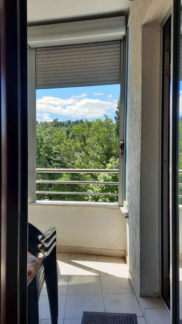 Pogled na osvijetljenu terasu sa koje se pruža pogled na drveće.