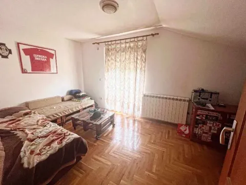 Manja spavaća soba sa krevetom, drvenim parketom i prozorom prekrivenim zavesama. - image 7