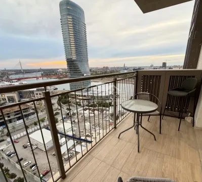 Namešten balkon sa garniturom za sedenje i pogledom na grad i reku. - image 14